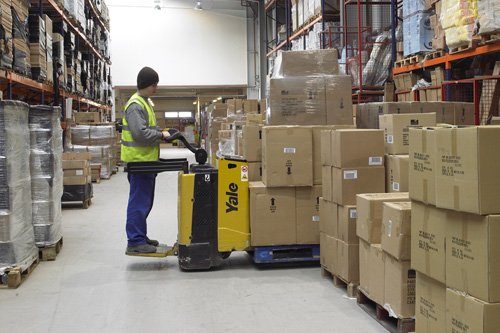 trabajador en almacen cargando cajas.